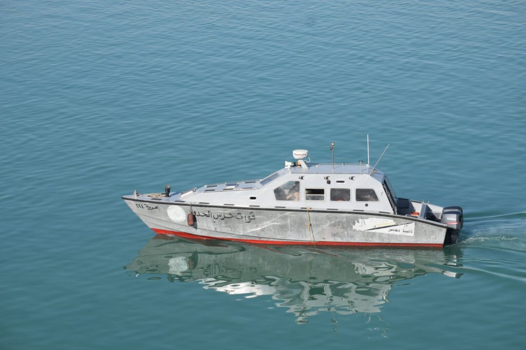 Navy patrol boat cruising on serene waters in Egypt, reflecting on the sea's surface.