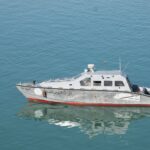 Navy patrol boat cruising on serene waters in Egypt, reflecting on the sea's surface.
