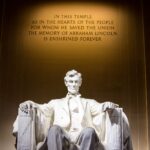 Illuminated Lincoln Memorial statue with engraved quote, Washington D.C.