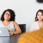 Diverse women engaged in a business meeting with laptop, showcasing teamwork and collaboration.