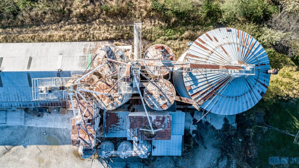 Aerial view of abandoned, rusty industrial containers in Fulton, MO, showcasing decay and industry.