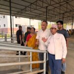 A group of people visiting a rural industrial site, discussing the surroundings.