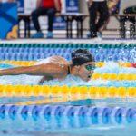 A swimmer in a race swimming the butterfly stroke during a competitive event.