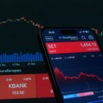 Mobile app showing stock market data with charts on screen.