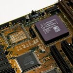 Detailed view of a vintage motherboard with an AMD microchip, showcasing intricate circuitry and slots.