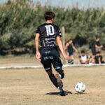 A dynamic soccer scene with young athletes striving for the ball in a local match outdoors.