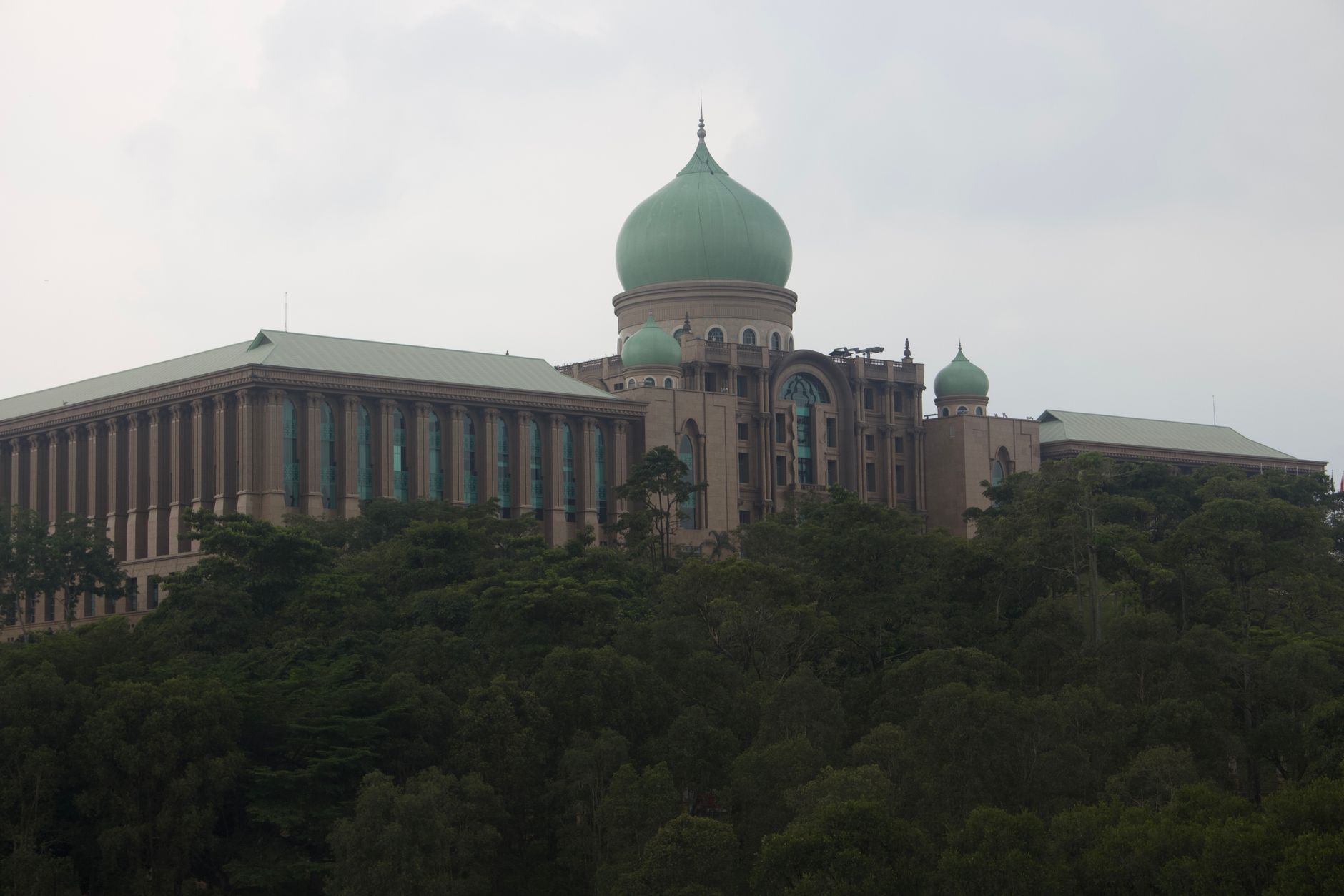 Scenic view of Malaysia's Prime Minister's Office in Putrajaya surrounded by lush greenery.