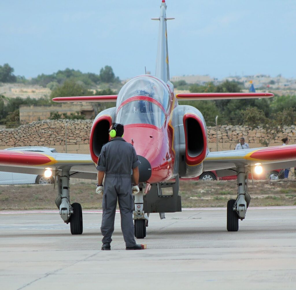 Ground crew member marshaling a jet at Malta's Luqa Airport.