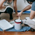 A couple paints their new home together, preparing walls for a fresh look.