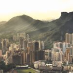 Aerial view of a sprawling city with mountain landscape at sunrise.