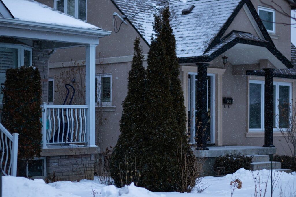 Charming Toronto house covered in snow during a serene Canadian winter day.