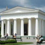 Captured in Burggarten, Vienna, this neoclassical temple stands against a vibrant city backdrop.