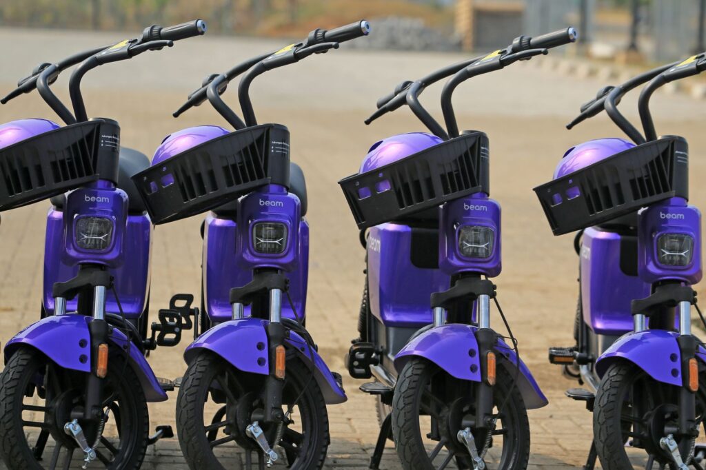 A group of violet electric scooters parked in an urban setting, ready for eco-friendly city commuting.