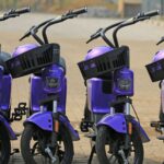 A group of violet electric scooters parked in an urban setting, ready for eco-friendly city commuting.