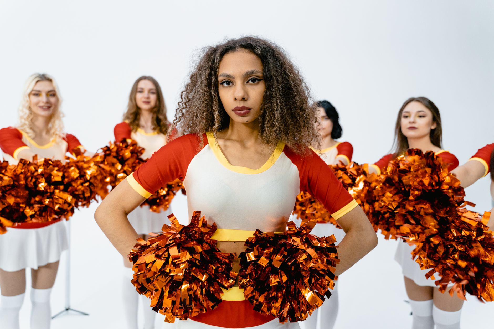 Group of cheerleaders showcasing team spirit with vibrant pom poms and uniforms.