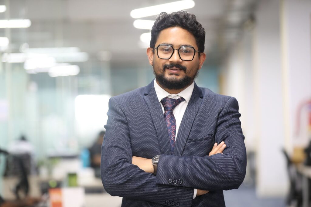 Confident man in a suit standing in a modern office, showcasing professionalism.