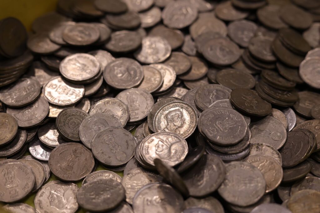 Collection of vintage Indian coins with various historical figures and details.