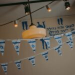 Indoor decor with Israeli flag banners and string lights creating a festive atmosphere.