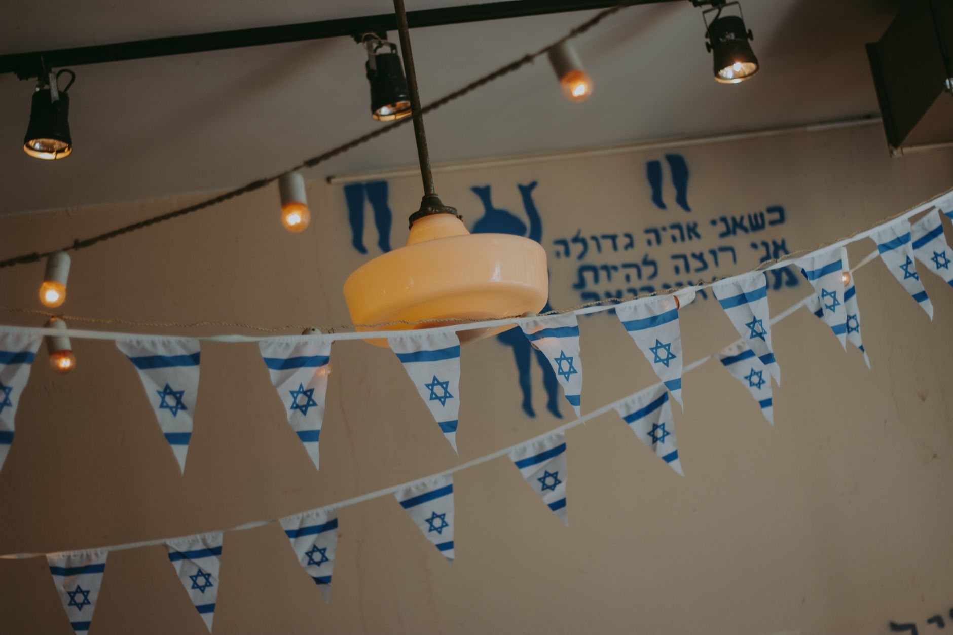 Indoor decor with Israeli flag banners and string lights creating a festive atmosphere.