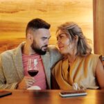 A loving couple sharing a romantic moment with red wine in a stylish restaurant.