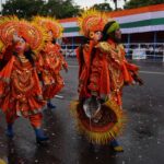 Participants in traditional costumes march during a colorful festival parade in Kolkata, India.