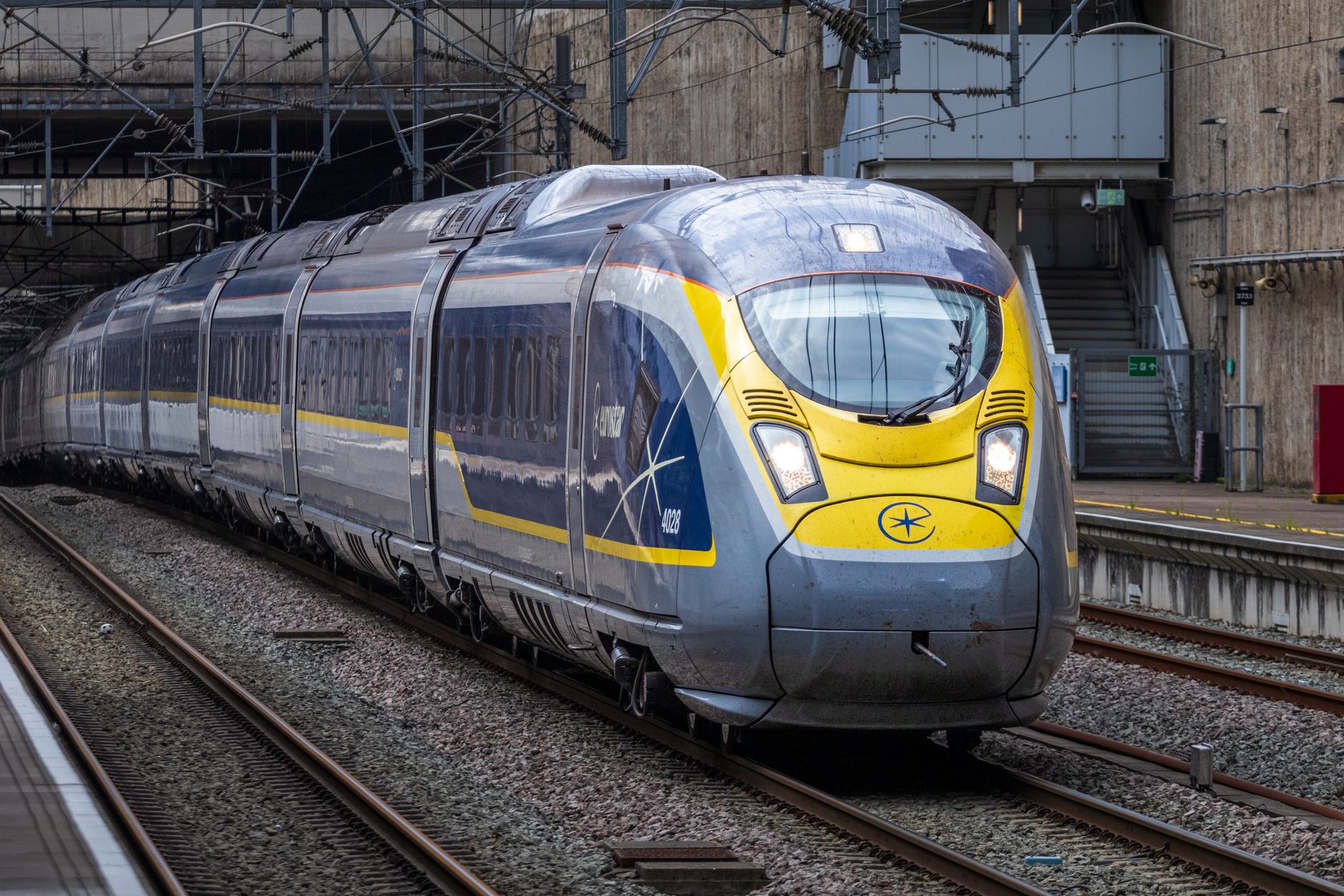 A modern high-speed train entering a city station, emphasizing speed and technology.