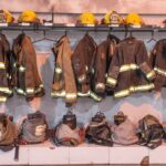 Rows of hanging firefighter gear and helmets in a Buenos Aires station.