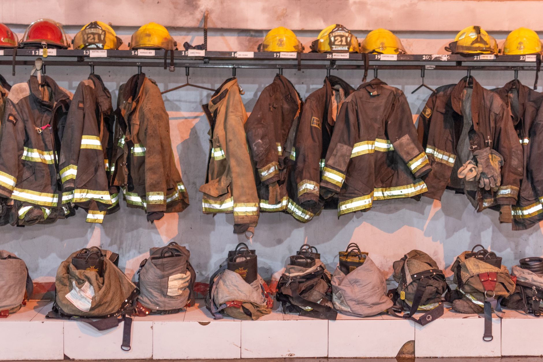 Rows of hanging firefighter gear and helmets in a Buenos Aires station.