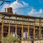 A dramatic view of an abandoned industrial structure in Delhi, India under a vibrant sky.