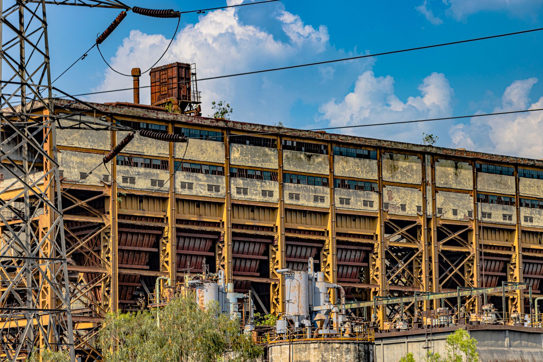 A dramatic view of an abandoned industrial structure in Delhi, India under a vibrant sky.