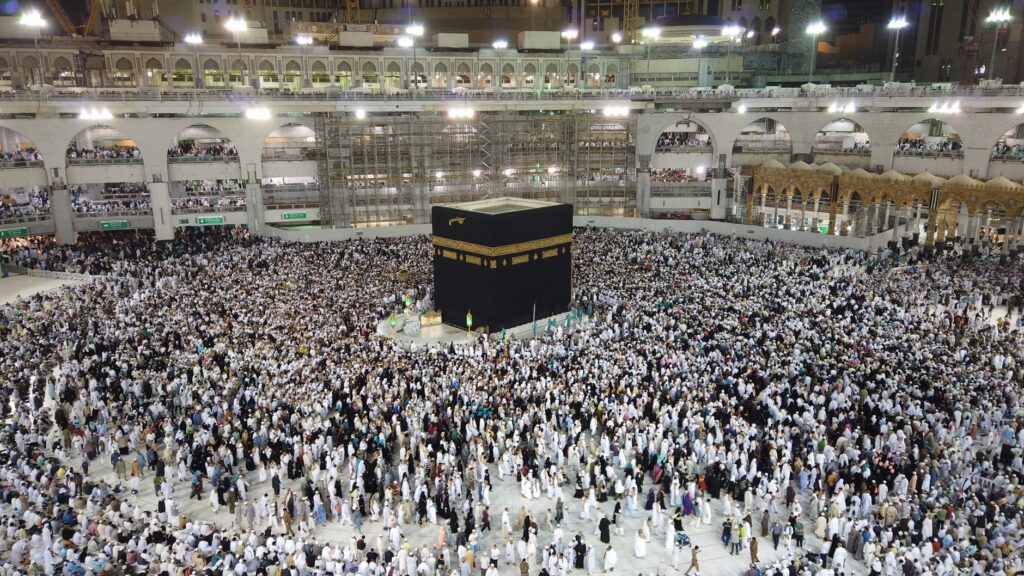 Aerial view of thousands of pilgrims gathered around the Kaaba at night in Mecca, Saudi Arabia.