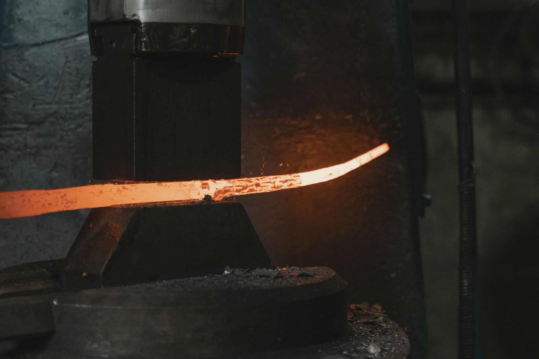 Close-up of hot iron being shaped in a forge, highlighting intense heat and craftsmanship.