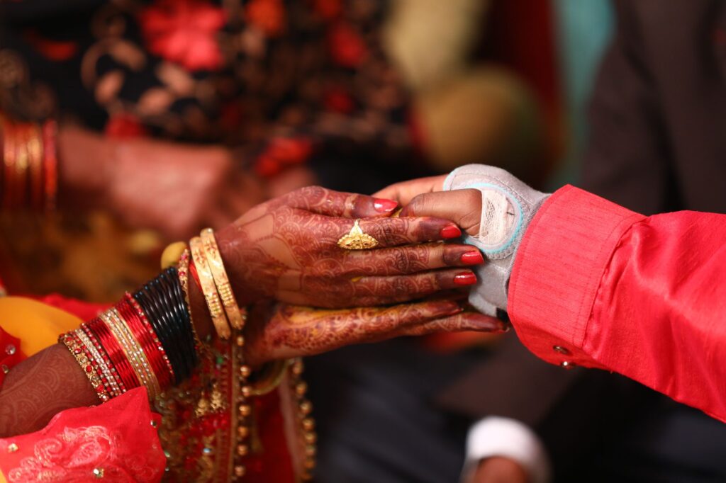 Close-up of Indian bride and groom holding hands during a wedding ceremony in Lucknow, India.