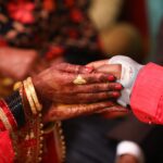 Close-up of Indian bride and groom holding hands during a wedding ceremony in Lucknow, India.